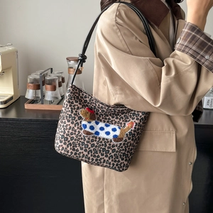 Sac seau léopard avec broderie de teckel sur un mannequin dans un cadre décontracté