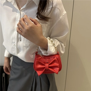 Chic red mini square bag with oversized bow detail and elegant white pearl handle