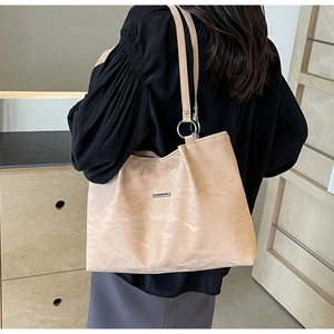 Detail of beige large tote bag with metal hardware and wrinkled texture leather