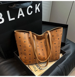 Detail of a brown tote bag featuring bear patterns and a textured leather surface