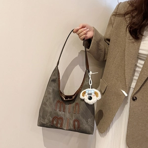 Retro grey suede large tote bag with brown logo and cute white puppy plush keychain