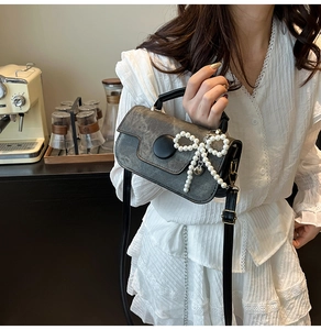 Détail du mini sac gris avec pendentif papillon en perles et fermoir magnétique noir