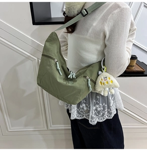 Olive green nylon dumpling bag close-up showing water-resistant fabric and utility pockets