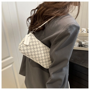 Detail of grey monogram underarm bag with M-pattern and Fashion & Bags leather tag