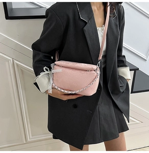 Pink snake-embossed square bag with silver chain, lace and pearl charm detail shown on shoulder