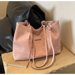 Detail of light pink tote bag featuring unique marble texture leather and silver metal rings