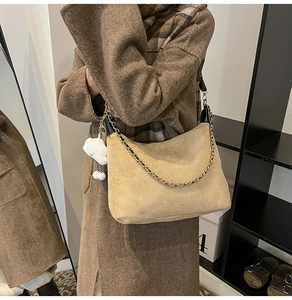 Détail du sac demi-lune beige en daim avec chaîne dorée et breloque peluche