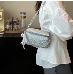 Close-up of silver snake pattern crossbody bag with metal chain and pearl lace charm