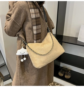 Détail du sac fourre-tout en daim kaki avec bandoulière en chaîne et pendentif nuage doux