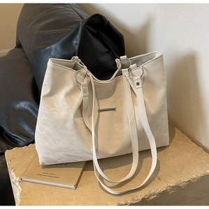 Detail of cream large tote bag showing wrinkled leather texture and silver metal ring