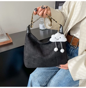 Détail du sac croissant en daim noir avec poignée en chaîne et pendentif nuage doux
