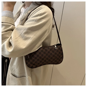 Brown monogram crescent shoulder bag with M pattern shown on model in profile view