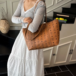 Brown tote bag with bear print featuring double handles and long strap on model
