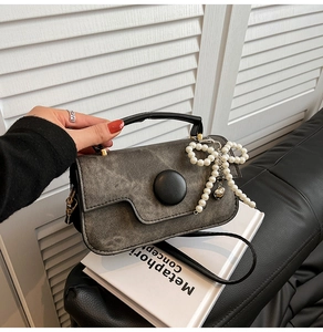 Sac à bandoulière en denim lavé gris avec boucle décorative et pendentif nœud en perles