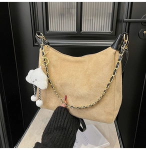 Détail du sac hobo en daim beige avec bandoulière dorée et breloque nuage mignonne