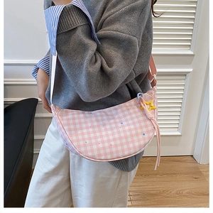 Détail du sac dumpling à carreaux roses avec motifs étoiles et pendentif étoile jaune