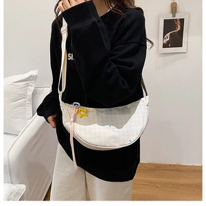 Détail du sac dumpling à carreaux jaunes avec motifs d'étoiles et bandoulière