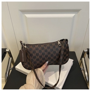 Close-up of brown M-patterned baguette bag with silver hardware and fashion leather tag