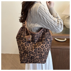 Detail of a large leopard print tote bag with a matching small hanging pouch charm