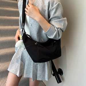 Fashionable black nylon half-moon crossbody bag with adjustable strap and cute plush charm