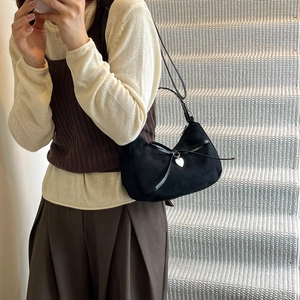 Retro black matte dumpling bag with leather bow and silver heart pendant on model