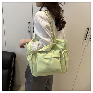 Dettaglio della borsa tote in nylon verde chiaro con multitasche e tracolla