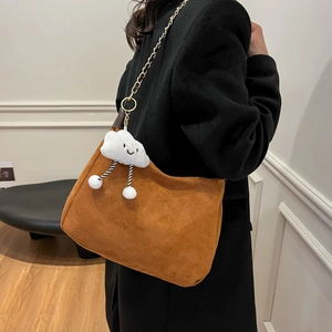 Sac cabas en daim marron avec chaîne dorée et breloque nuage porté à l'épaule pour femme