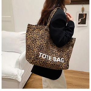Nahaufnahme der Leopard-Print-Einkaufstasche mit weißem TOTE BAG-Text am Model