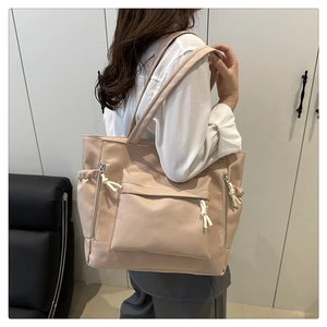 Dettaglio della borsa tote rosa nudo con design multitasche e trama con coulisse