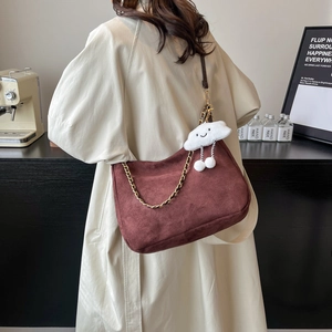 Sac fourre-tout chic en daim bordeaux avec chaîne dorée et pendentif nuage sur un mannequin