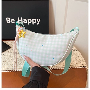 Détail du sac bandoulière croissant à carreaux avec motifs étoiles et pendentif étoile