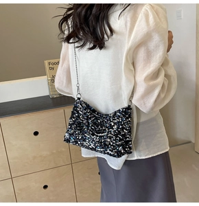 Detail of a sparkling black sequin shoulder bag with elegant silver chain strap for women