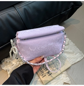 Detail of light purple snakeskin square bag with silver chain and pearl heart pendant