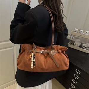 Caramel faux suede tote bag with wooden bead tassel shown on a fashion model