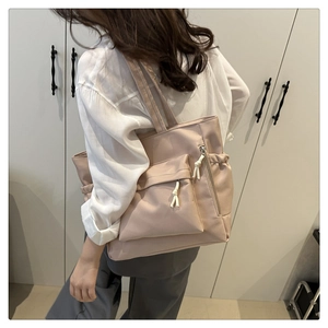Detail of dusty pink tote bag showing side drawstring pocket and shoulder wear style