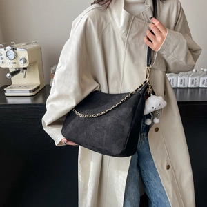 Sac cabas minimaliste en daim noir avec chaîne dorée et pendentif nuage blanc en situation