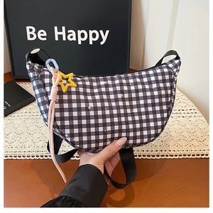 Détail du sac demi-lune à damier avec imprimé étoile et pendentif étoile jaune