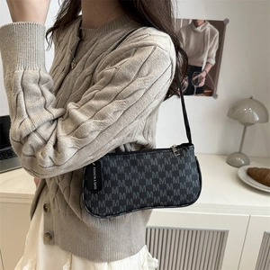 Fashionable black baguette shoulder bag with M-pattern monogram and side tag