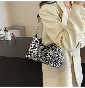 Close-up of sparkling silver sequins and metal chain strap on a stylish shoulder bag