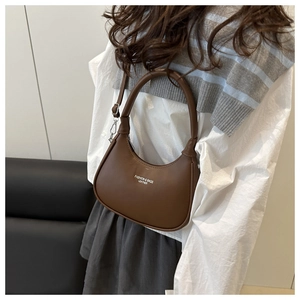 Detail of dark brown crescent bag showing matte leather texture and adjustable strap