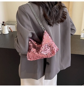 Detail view of pink sequin shoulder bag featuring shiny round textures and silver chain strap