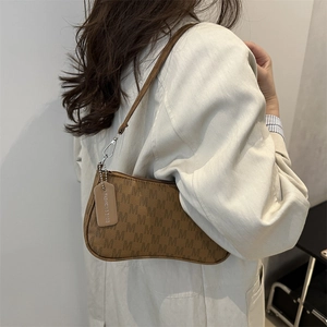 Brown monogram shoulder bag with M pattern and slim strap on beige blazer model
