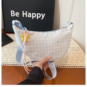 Détail du sac à carreaux bleus avec pendentif étoile et sangle rose tenue en main