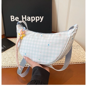 Détail du sac dumpling à carreaux bleus avec motifs d'étoiles et pendentif étoile jaune