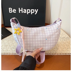 Détail du sac demi-lune à carreaux lavande avec motifs d'étoiles et pendentif étoile jaune