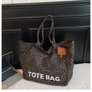 Makroaufnahme von Leopard-Canvas und orangefarbenem Lederetikett auf der großen Tote Bag