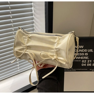Close-up of cream pillow bag with pleated leather texture and delicate bow details