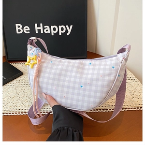 Détail du sac violet à carreaux avec pendentif étoile et bandoulière en tissu