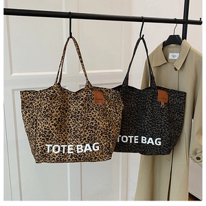 Detailaufnahme der Leopard-Tragetaschen in Braun und Grau mit Markenetiketten aus Leder