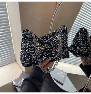 Detail view of sparkly sequin shoulder bag with silver metal chain and zipper